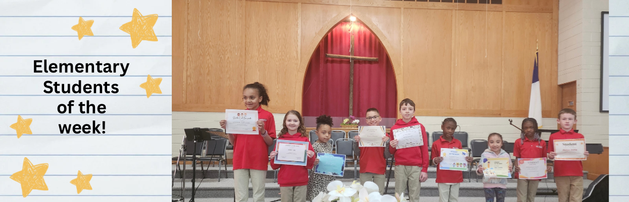 Elementary kids in red shirts and khaki pants lined up on stage with student of the week certificates